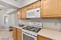 kitchen featuring light tile patterned floors and white appliances