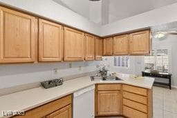 kitchen with light tile patterned floors, white dishwasher, ceiling fan, and sink