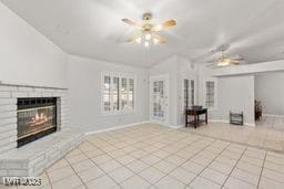 unfurnished living room with a fireplace, light tile patterned floors, and ceiling fan