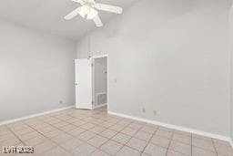 spare room with light tile patterned floors, high vaulted ceiling, and ceiling fan