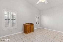 tiled empty room featuring ceiling fan and high vaulted ceiling