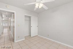 unfurnished bedroom with light tile patterned floors, a closet, and ceiling fan