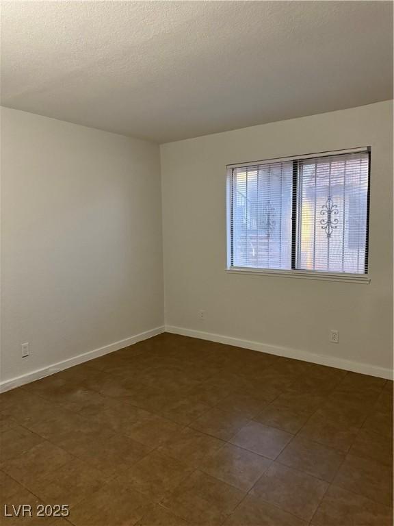 empty room with dark tile patterned floors