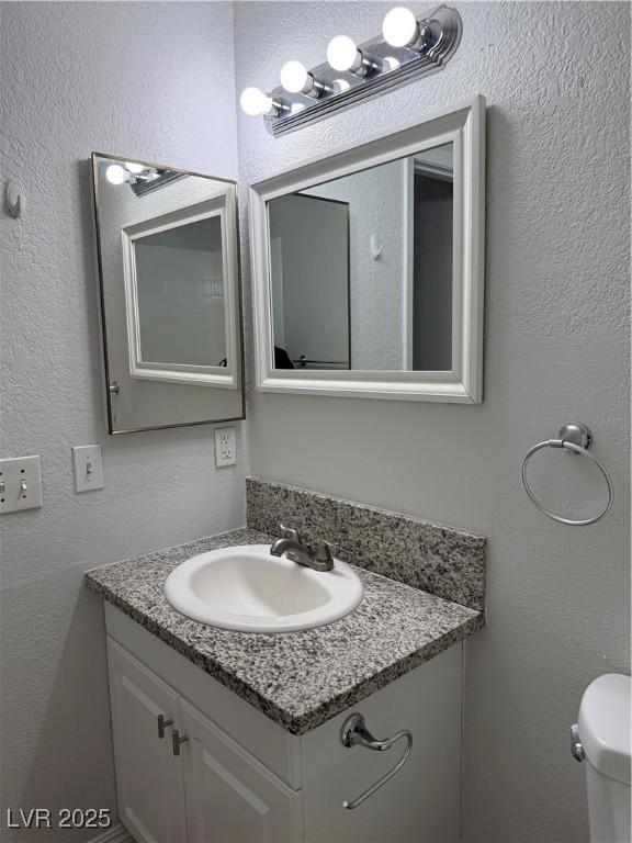 bathroom featuring vanity and toilet