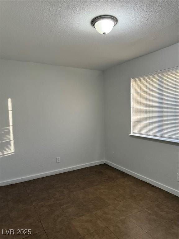 unfurnished room featuring a textured ceiling