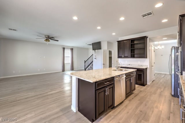 kitchen featuring appliances with stainless steel finishes, dark brown cabinetry, sink, a center island with sink, and light hardwood / wood-style floors