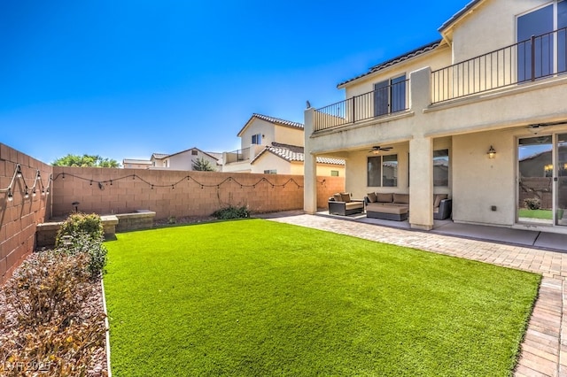 view of yard with outdoor lounge area, a balcony, ceiling fan, and a patio area