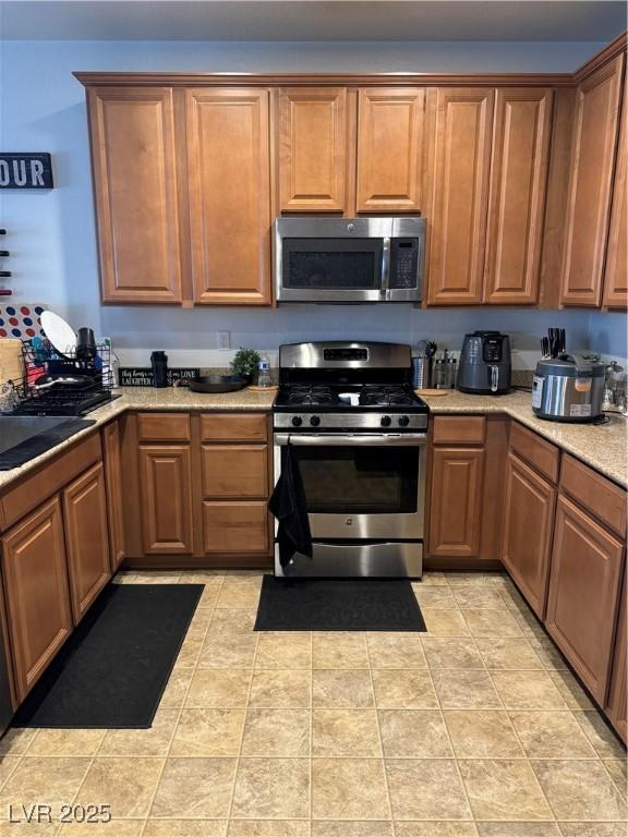 kitchen featuring light tile patterned flooring, sink, and appliances with stainless steel finishes