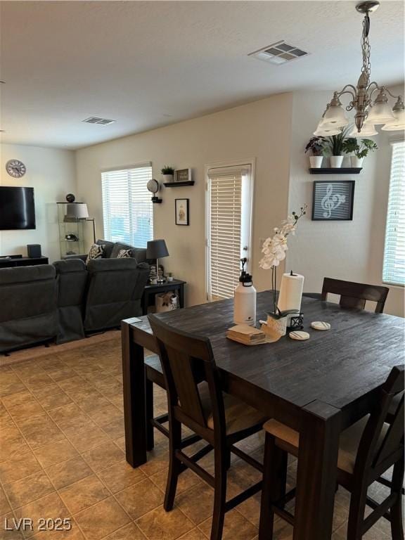 dining room with an inviting chandelier and light tile patterned flooring