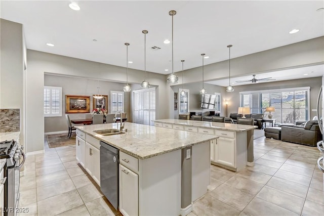 kitchen featuring ceiling fan, sink, an island with sink, and stainless steel appliances