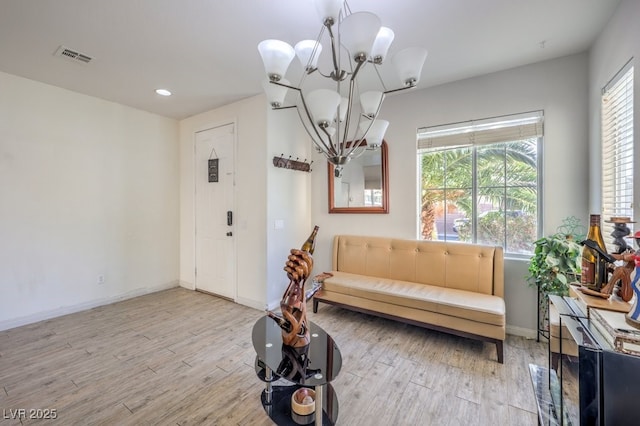 living area with a chandelier and light hardwood / wood-style floors