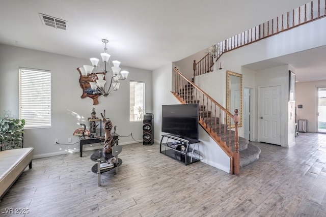 living room with hardwood / wood-style floors, a wealth of natural light, and a chandelier