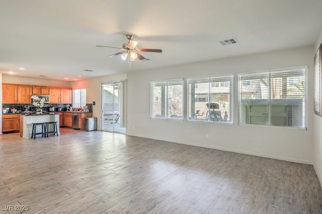 unfurnished living room featuring light wood-type flooring and ceiling fan