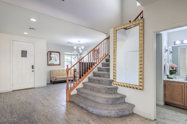 foyer entrance with a notable chandelier and light hardwood / wood-style floors