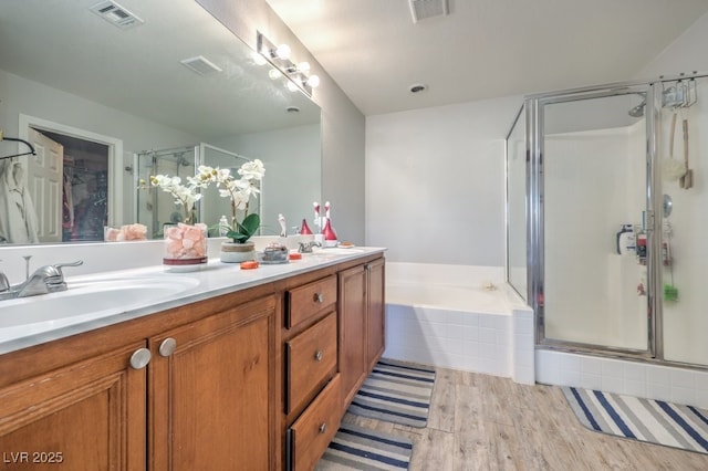 bathroom with vanity, wood-type flooring, and plus walk in shower