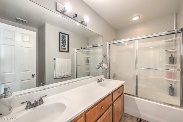 bathroom with vanity, hardwood / wood-style flooring, and enclosed tub / shower combo