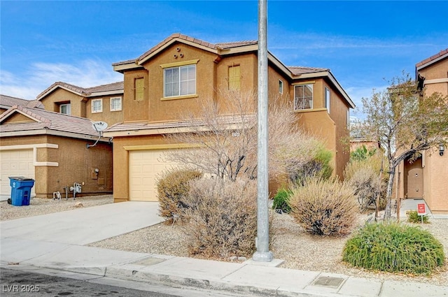 multi unit property featuring concrete driveway, a garage, and stucco siding