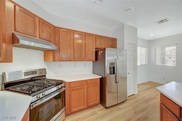 kitchen featuring light countertops, light wood-style floors, under cabinet range hood, and stainless steel appliances