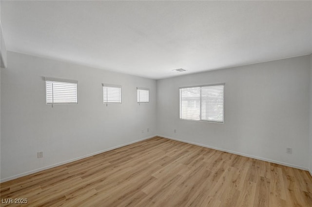 unfurnished room with visible vents, baseboards, and light wood finished floors