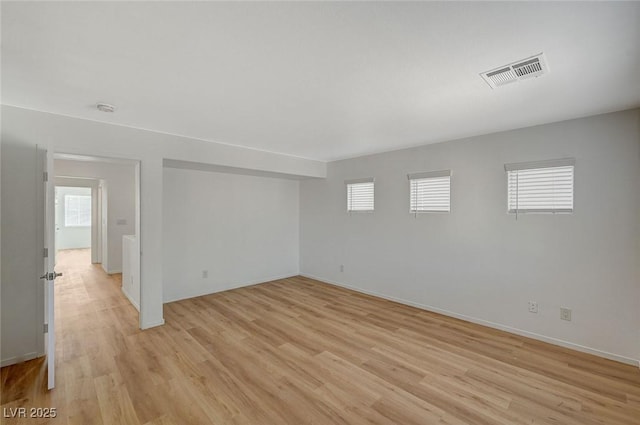 spare room with light wood finished floors, visible vents, baseboards, and a wealth of natural light