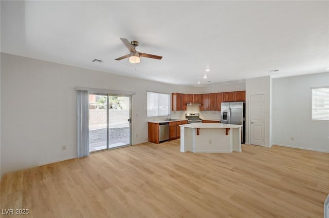 kitchen with visible vents, appliances with stainless steel finishes, open floor plan, and light countertops