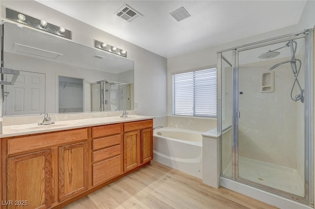 bathroom featuring a sink, a garden tub, visible vents, and a stall shower