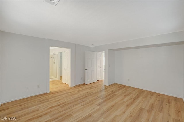 empty room with visible vents, baseboards, and light wood finished floors