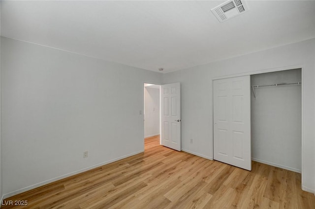 unfurnished bedroom with visible vents, baseboards, a closet, and light wood finished floors