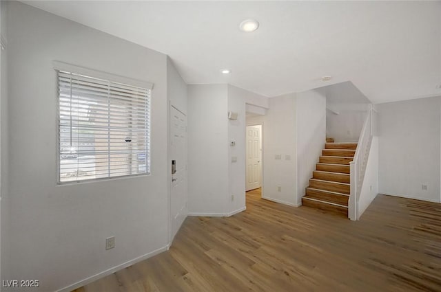 foyer entrance with stairway, recessed lighting, baseboards, and wood finished floors