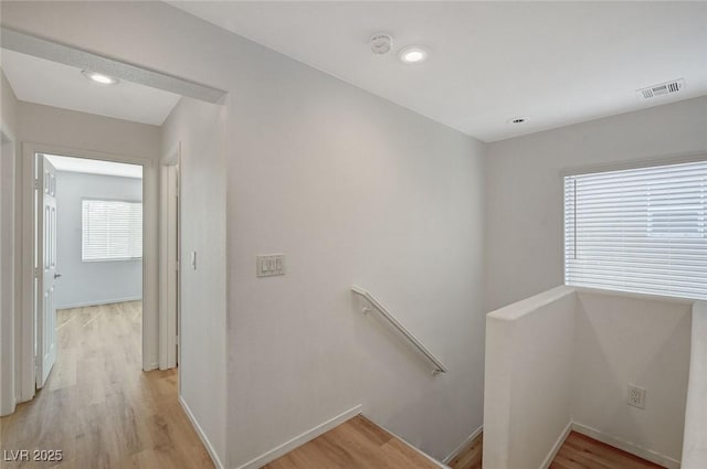 staircase featuring visible vents, baseboards, and wood finished floors