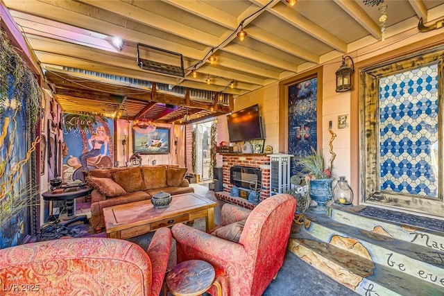 living room featuring beamed ceiling and a fireplace