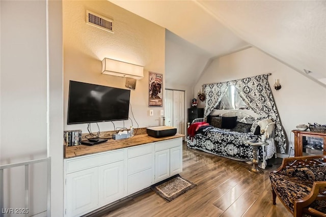 bedroom with hardwood / wood-style floors and lofted ceiling