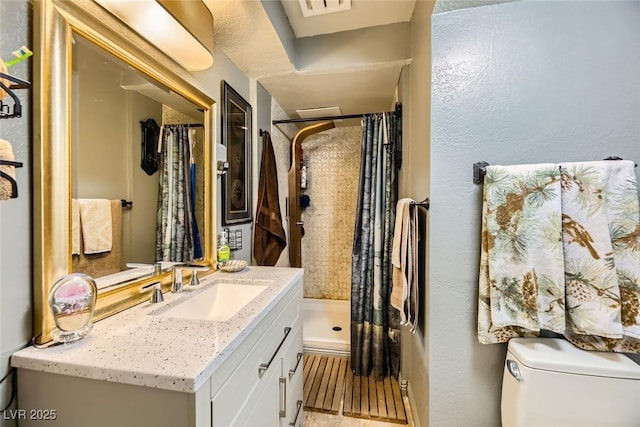 bathroom featuring walk in shower, vanity, and toilet