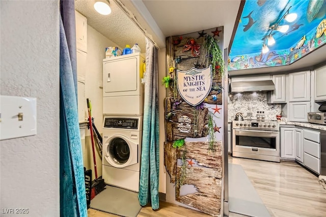 washroom featuring light hardwood / wood-style flooring and stacked washer and clothes dryer