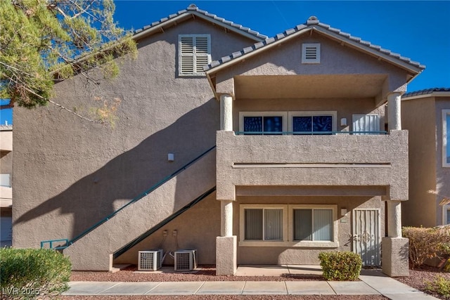 rear view of property with central air condition unit and a balcony