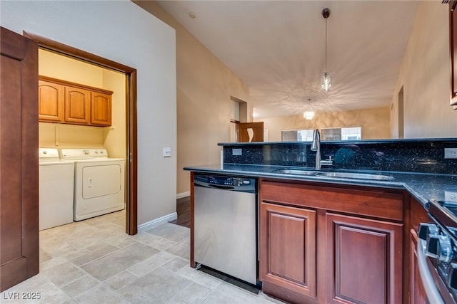 kitchen with pendant lighting, dark stone counters, sink, separate washer and dryer, and stainless steel appliances