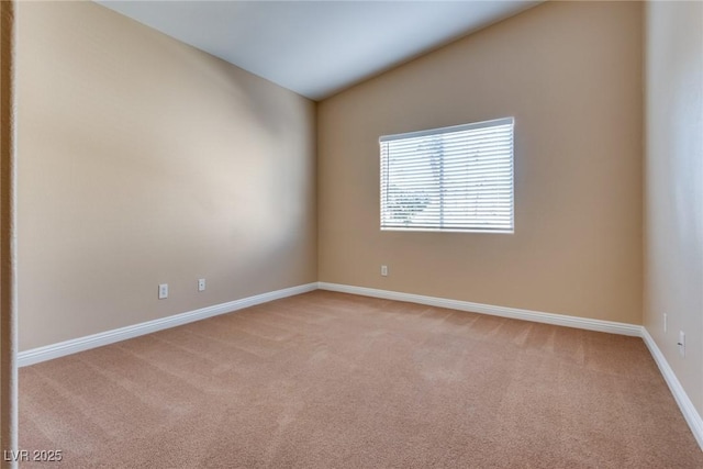 carpeted spare room with lofted ceiling