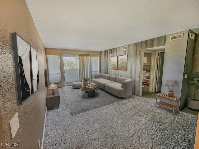 carpeted living room featuring a textured ceiling