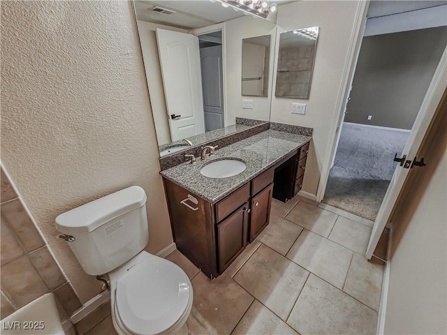 bathroom featuring tile patterned flooring, vanity, and toilet