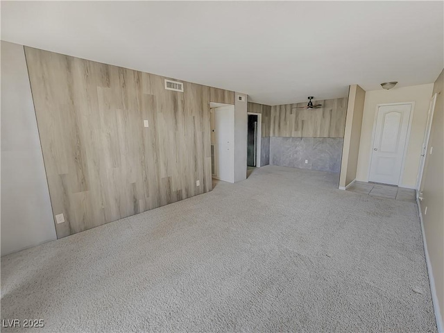 empty room featuring ceiling fan and light carpet