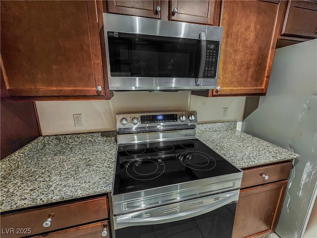 kitchen featuring light stone counters and appliances with stainless steel finishes