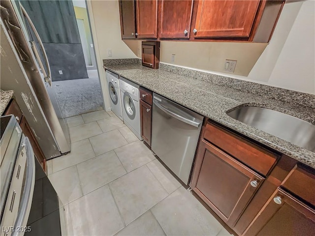 kitchen featuring dishwasher, light colored carpet, washer / clothes dryer, and stone counters