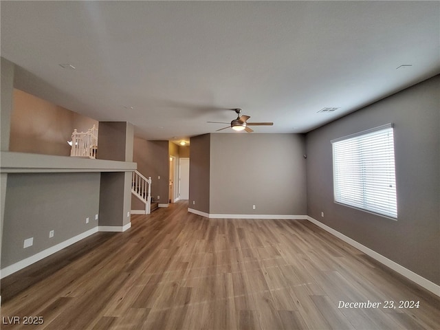 unfurnished living room with ceiling fan and hardwood / wood-style flooring