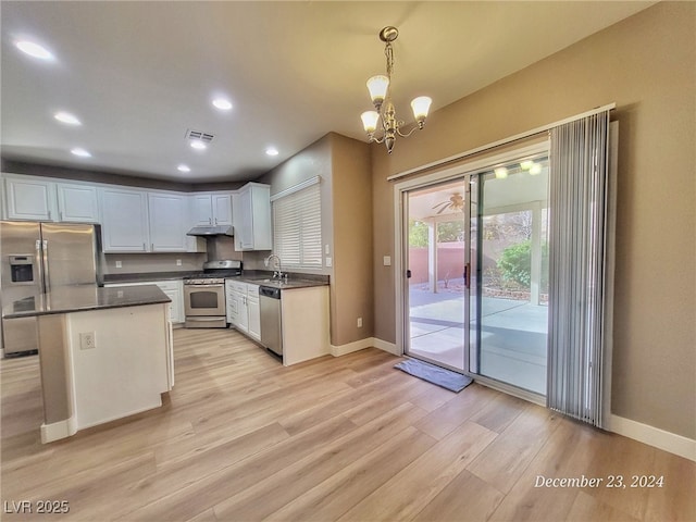 kitchen featuring appliances with stainless steel finishes, sink, pendant lighting, an inviting chandelier, and white cabinets