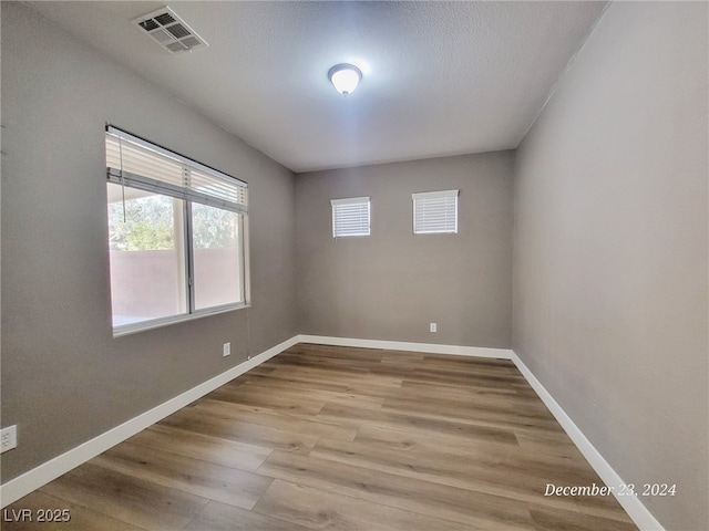 spare room featuring hardwood / wood-style floors and a textured ceiling