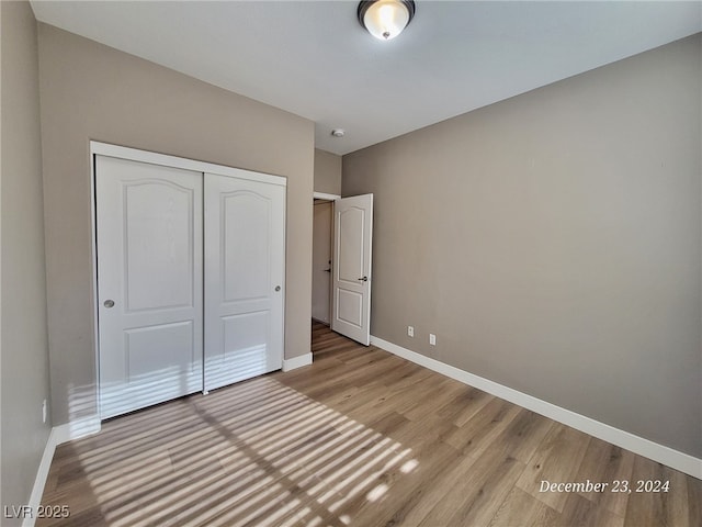 unfurnished bedroom featuring a closet and wood-type flooring