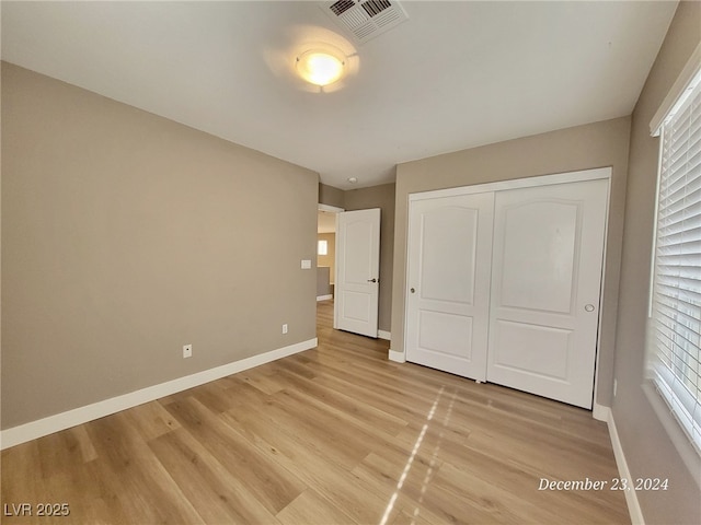 unfurnished bedroom featuring light hardwood / wood-style floors and a closet