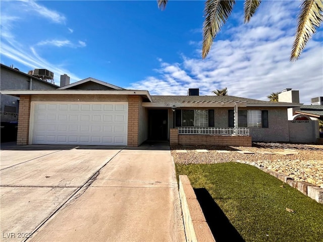 ranch-style home featuring central AC unit and a garage