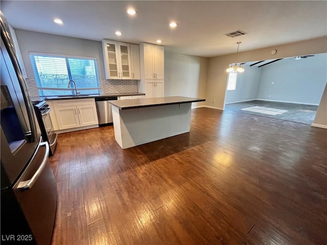 kitchen with a center island, sink, decorative backsplash, white cabinetry, and stainless steel appliances