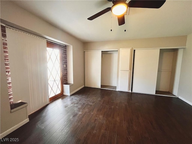 unfurnished bedroom featuring two closets, ceiling fan, and dark hardwood / wood-style floors